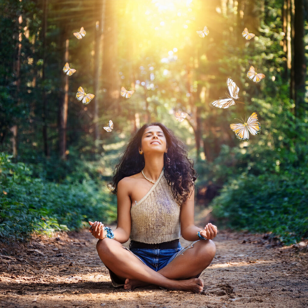 woman meditating with butterflies outside on path