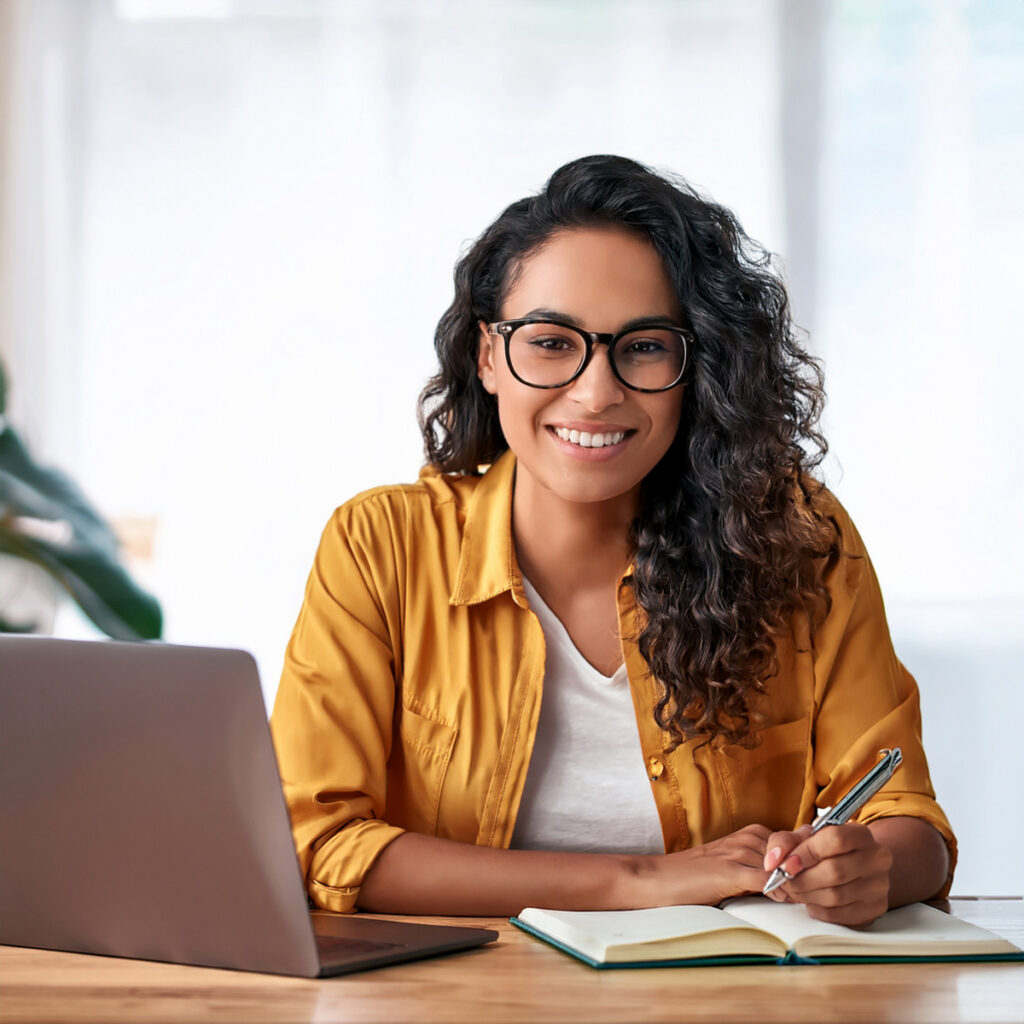 woman taking notes in front of laptop while listening to Metaphysically Minded™ Live Online Workshops